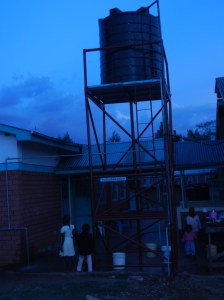 Water coming from the faucet on the kitchen building on the left.
