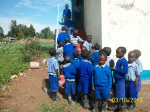 Kids lined up to check out the new latrine.  There are 3 more doors on the other side.