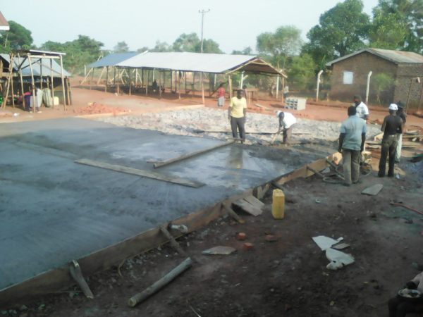 Concrete poured over the foundation, one wheel barrow load at a time.